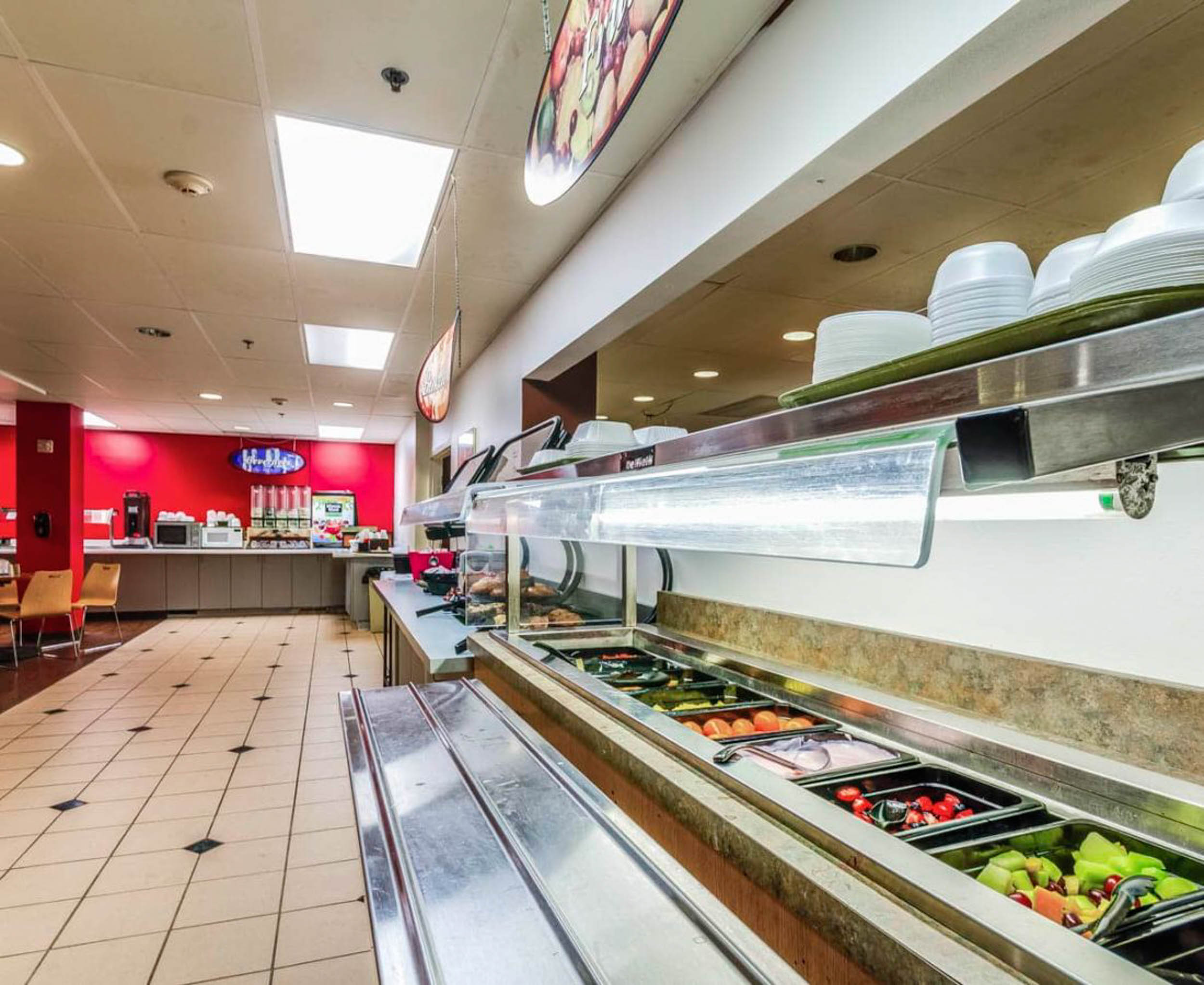 Cafeteria style salad bar with fruit and pastries