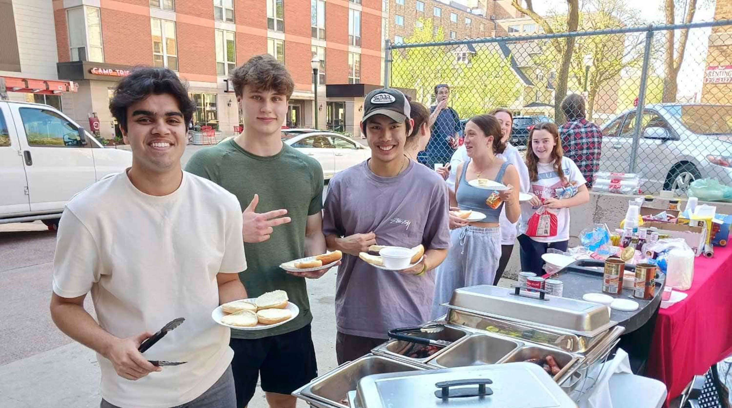 Residents enjoying community event with burgers and hotdogs